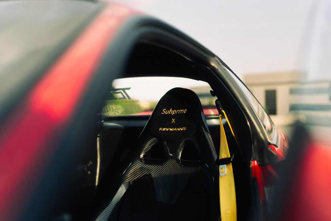 Kevmannz carbon fiber seat inside John Santos 1991 Toyota MR2 with yellow seat belt detail