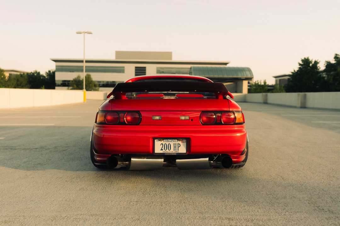 Rear view of John Santos 1991 Toyota MR2 showing dual exit exhaust and Ferrari Red finish