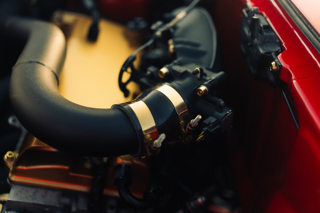 Close-up of throttle body and intake piping in John Santos 1991 Toyota MR2 engine bay