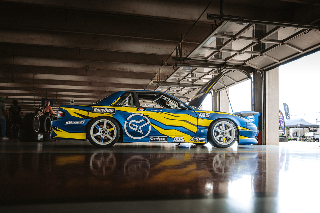 Nissan Silvia S13 drift car parked inside the FuelFest Dallas-Fort Worth paddock garage area at Texas Motor Speedway.