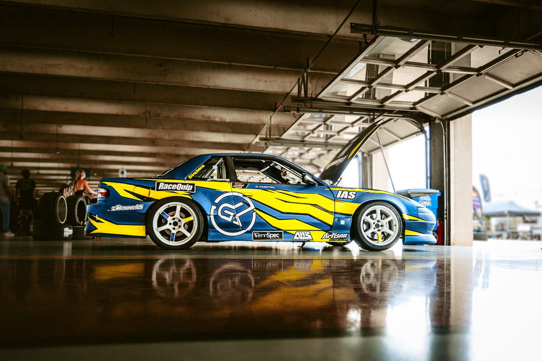 Nissan Silvia S13 drift car parked inside the FuelFest Dallas-Fort Worth paddock garage area at Texas Motor Speedway.