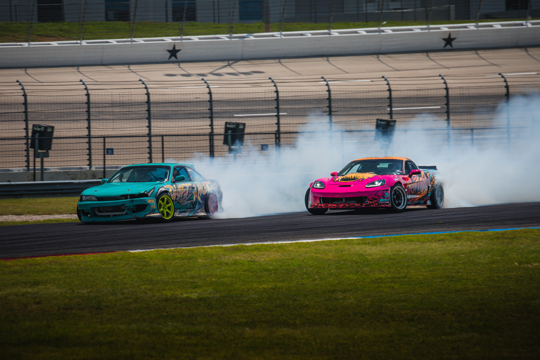Two drift cars running tandem during the drifting exhibition at FuelFest Dallas-Fort Worth inside Texas Motor Speedway.