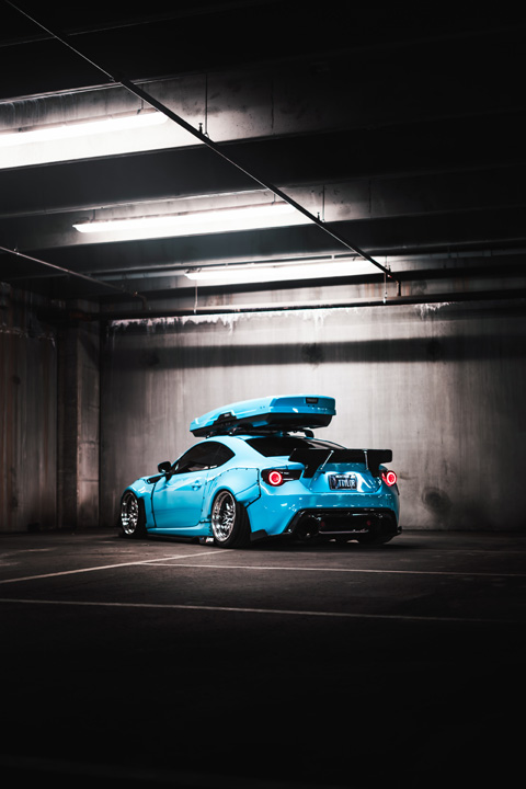 Rear three-quarter view of Nicholas Sargeant’s widebody 2016 Scion FR-S inside a dimly lit parking garage.