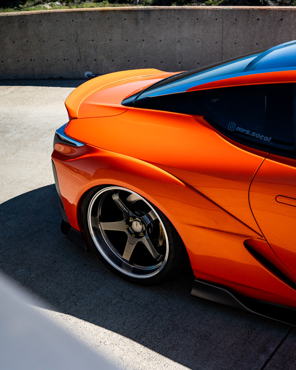 Rear quarter detail of Cassandra Balthasar’s orange widebody Lexus LC500 showing the Advan wheel and sculpted body lines.