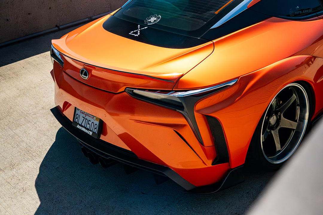 Rear detail of Cassandra Balthasar’s orange widebody Lexus LC500 showing the custom rear bumper, spoiler, and Advan wheel.