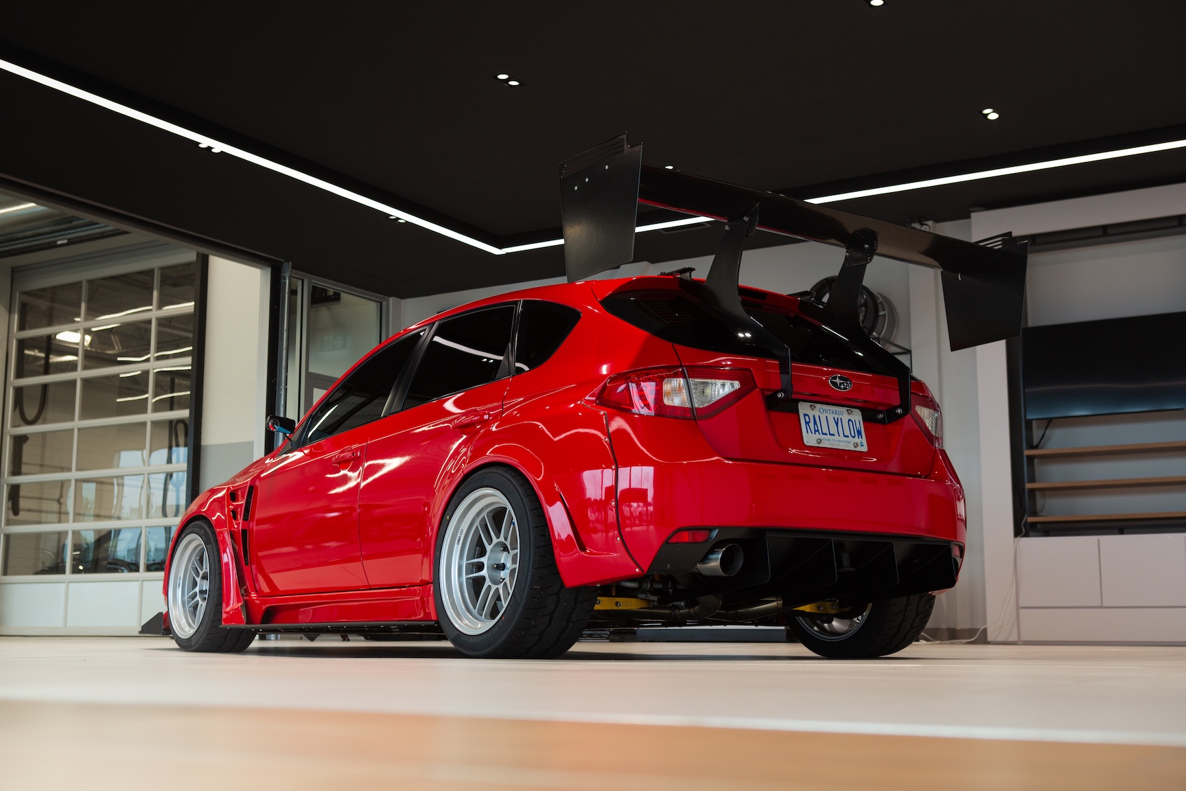 Jon Erickson’s red LS-swapped 2011 Subaru STi with widebody aero and track-focused details.