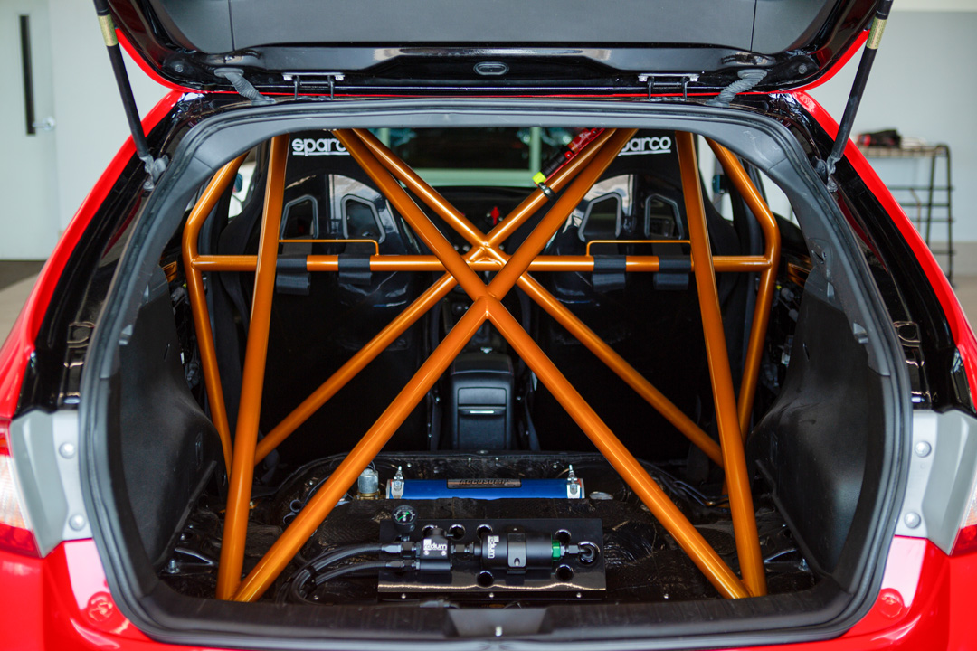 Jon Erickson’s red LS-swapped 2011 Subaru STi with widebody aero and track-focused details.