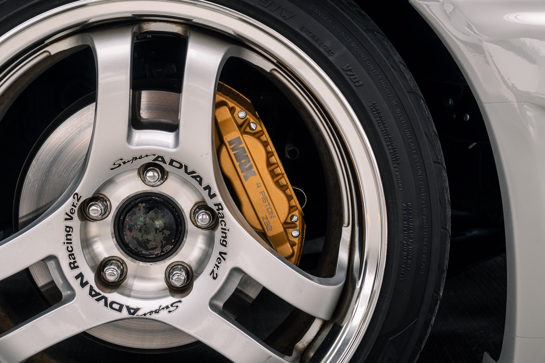 Close-up of Bill MacKenzie’s 2000 Nissan Silvia S15 showing the Super Advan Racing Ver.2 wheel, Yokohama tire, and Parts Shop Max front brake caliper.