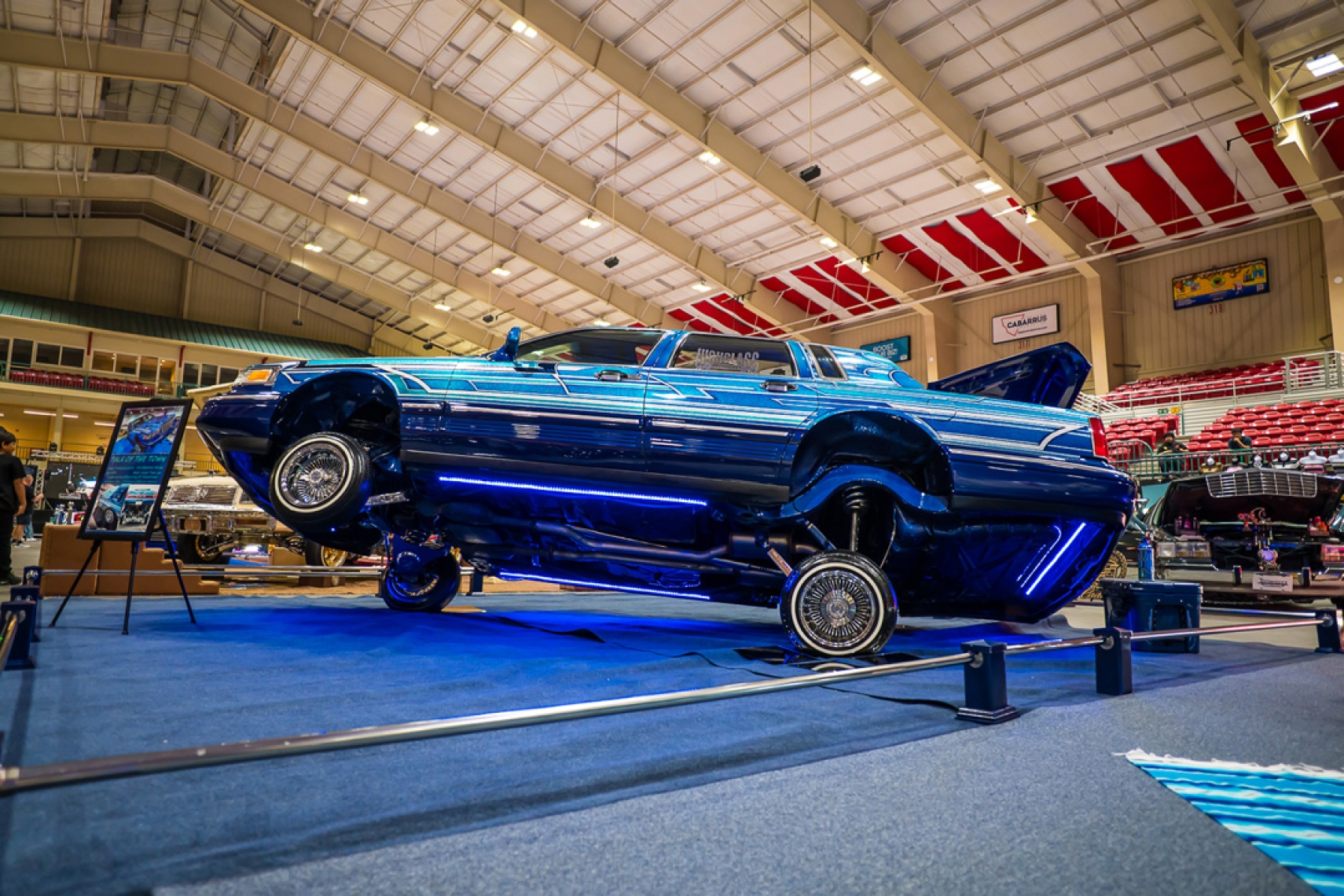 Blue custom lowrider displayed indoors at Lowrider Super Show Charlotte 2026 inside Cabarrus Arena &amp; Events Center in Concord, North Carolina.