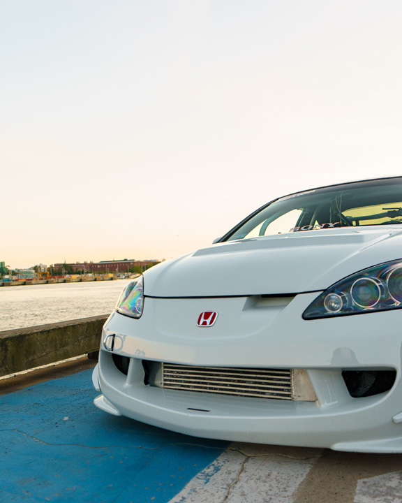Jonathan Ortiz’s 2005 Acura RSX Type-S with Porsche PTS Fashion Grey paint, Mugen aero, J’s Racing details, blue Volk Racing CE28N wheels, turbocharged K-series engine bay, DC5R interior conversion, and Sony ES audio setup.