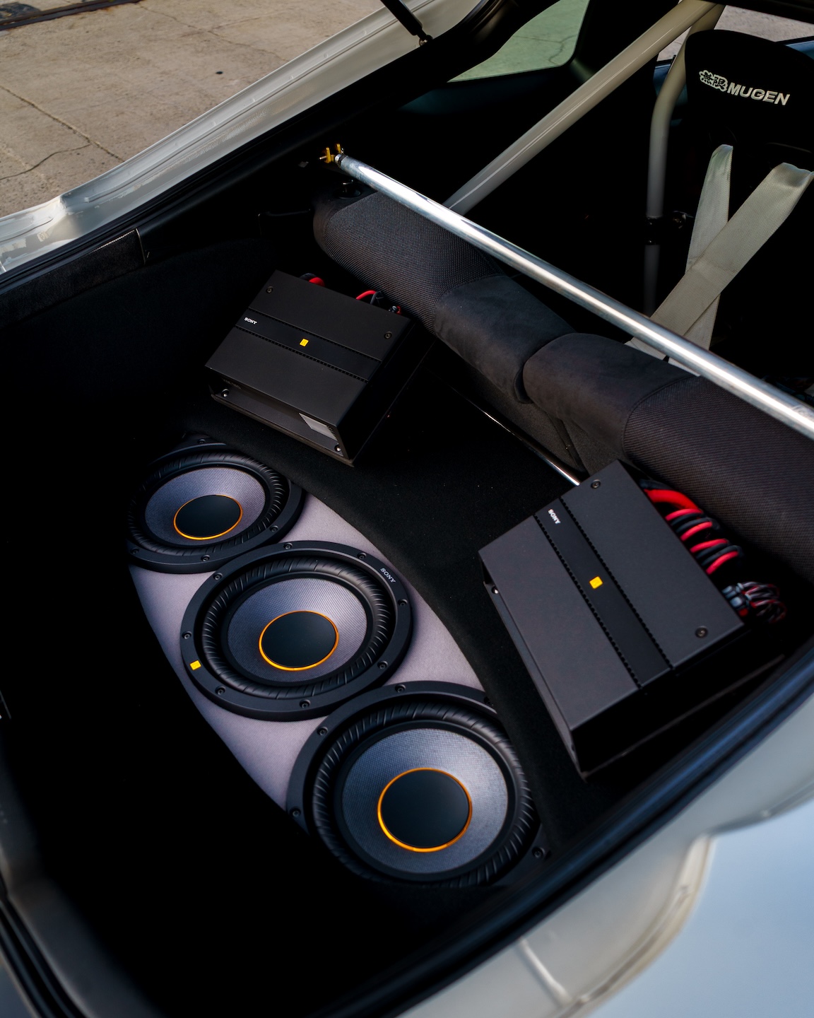 Trunk audio detail of Jonathan Ortiz’s 2005 Acura RSX Type-S showing the Sony ES amplifiers, Sony ES subwoofers, rear brace, DC5R interior conversion, and clean custom audio installation.