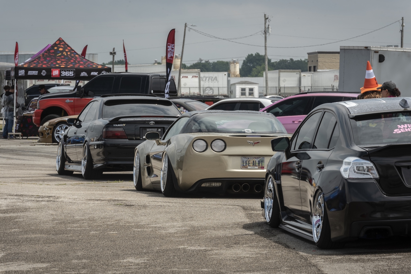 Modified vehicles lined up near the PASMAG Tuning365 Tour display at Formula DRIFT Indianapolis 2026.