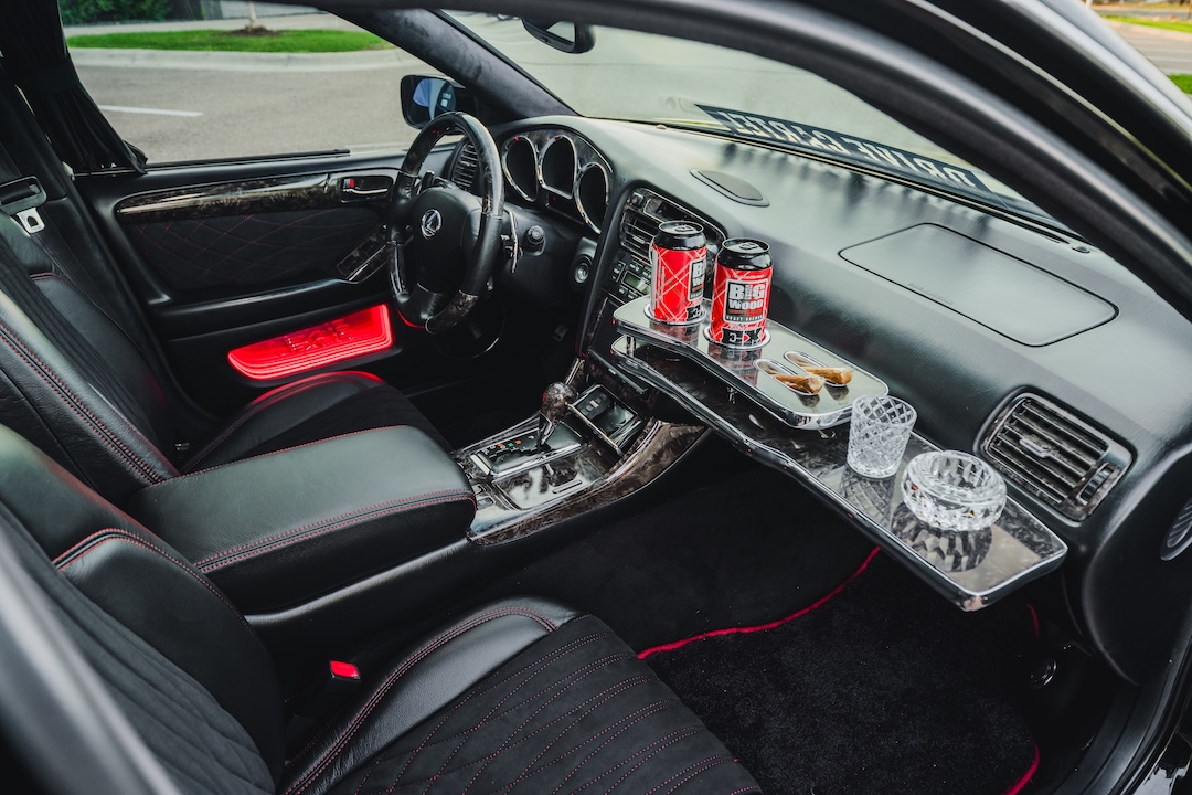 Interior of Kyle Harty’s 1999 Lexus GS 400 showing its custom leather upholstery, handmade VIP tray table, wood trim, and custom door panel.